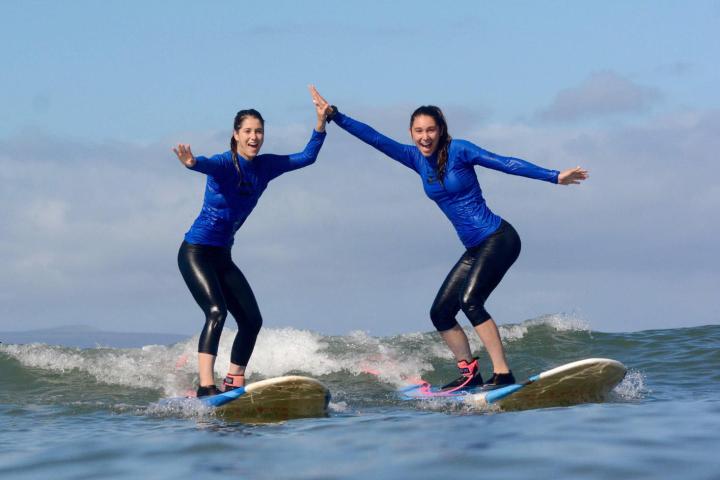 Girls surfing and high fiving